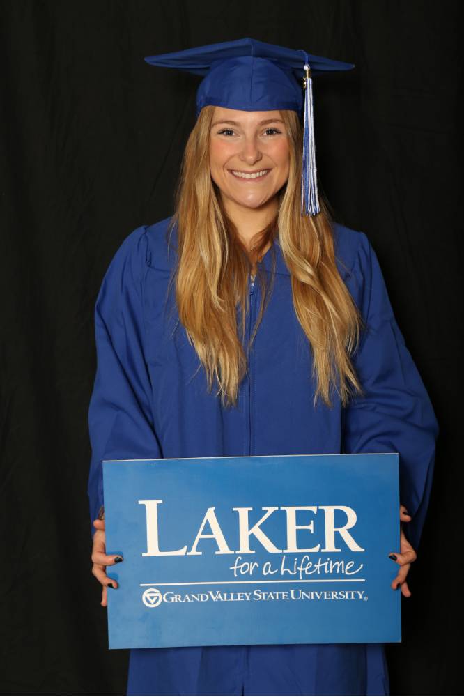 student poses with Laker for a Lifetime sign